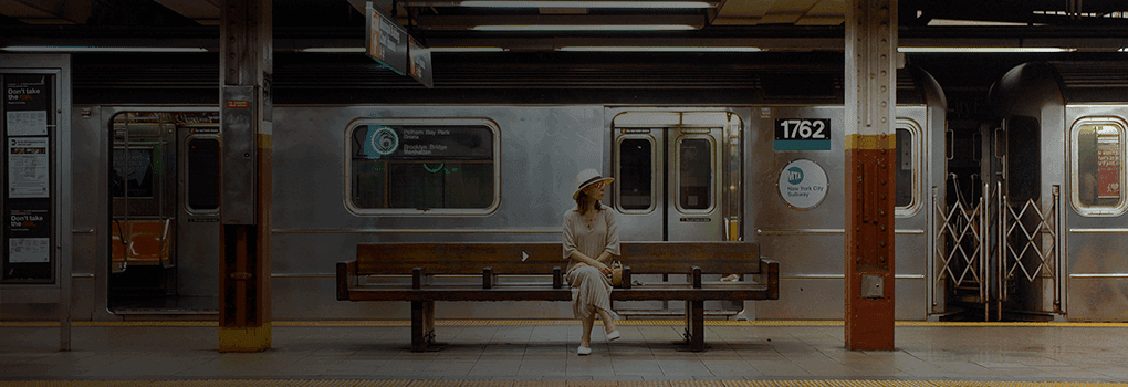 Footer banner with a woman waiting for a train